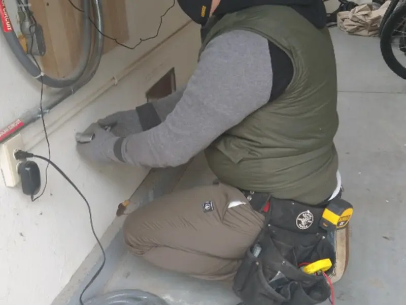 Electrician performing outlet wiring in a Johnstown garage